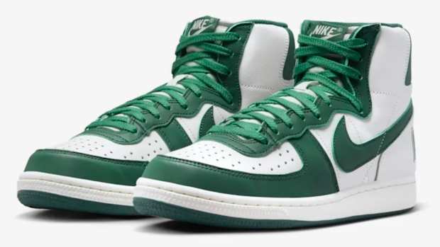 Side view of white and green Nike shoes.